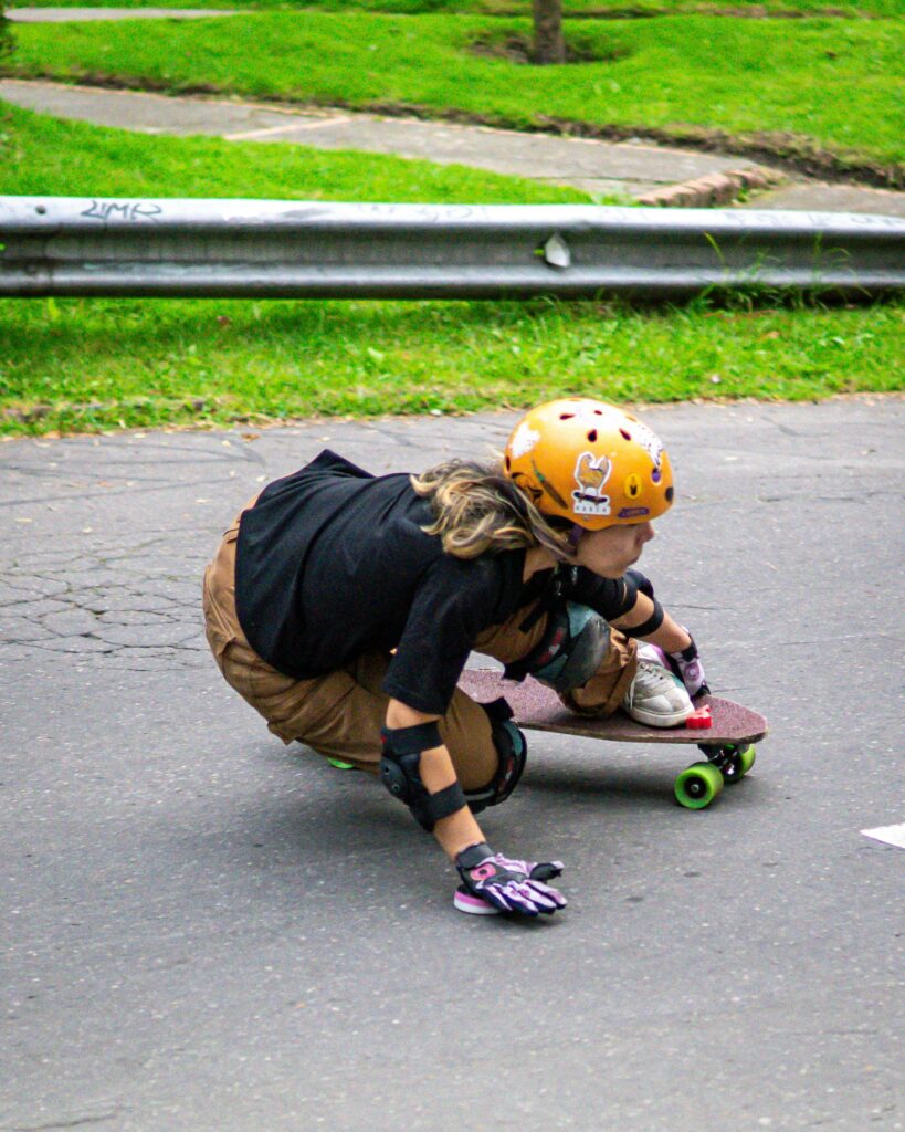 Skater in protective gear performing exciting tricks on a skateboard in a park setting.